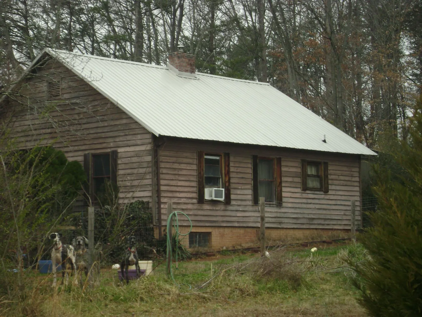 White metal roof on an old wood sided farmhouse, from a Metal Roof Installation job in Garnett